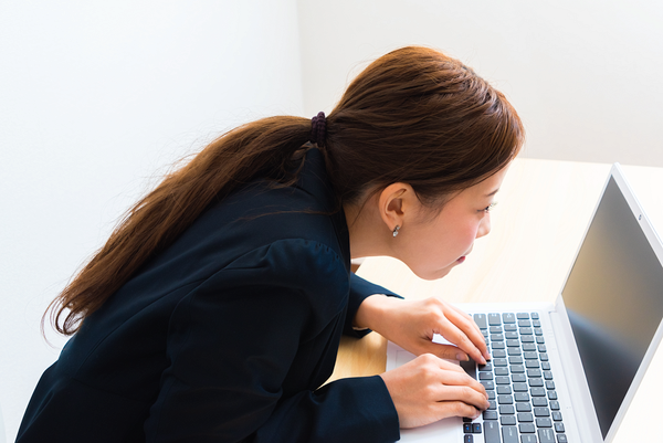 悪い姿勢でPC操作をする女性