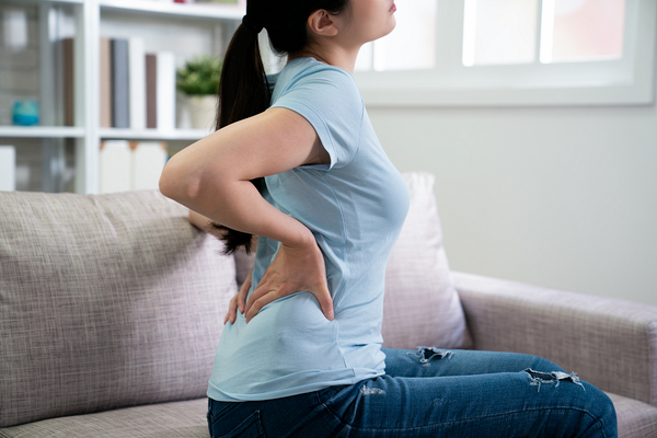 腰をおさえる女性