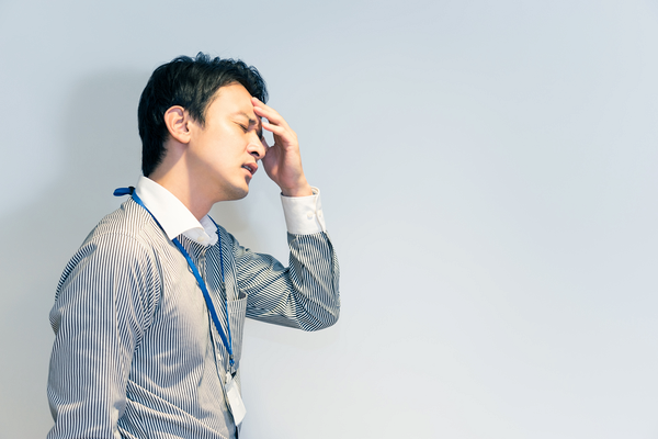 額を押さえる男性